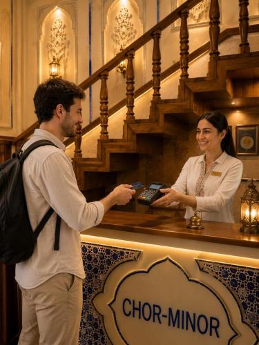a man and a woman standing behind a counter at Chorminor 1 min to Bukhara Old Town GET EARLY CHECK IN AND LATE CHECK OUT in Bukhara