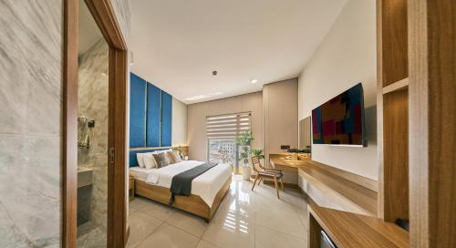 a bedroom with a bed and a desk and a television at Tran Long Hotel By Urban B in Ho Chi Minh City