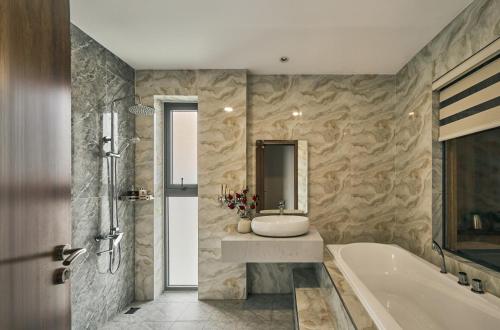 a bathroom with a tub and a sink and a bath tub at Tran Long Hotel By Urban B in Ho Chi Minh City