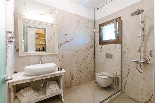 a bathroom with a sink and a glass shower at Byzantio Resort in Parga