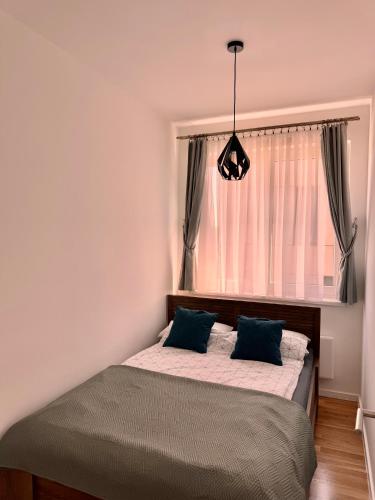 a bed with two pillows in a bedroom with a window at Bjelašnica Slope View in Bjelašnica