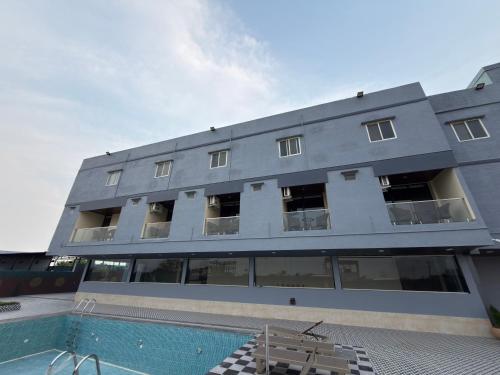 a building with a swimming pool in front of it at PARK CITY HOTEL & Resort in Gangāyapalle