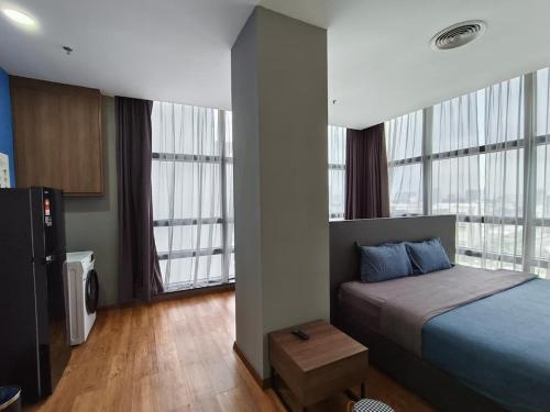 a bedroom with a bed and two large windows at Bangsar Trade Centre By WeCare in Kuala Lumpur