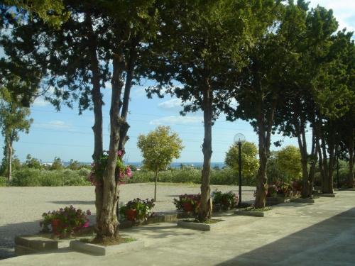 a row of trees in a park with flowers at Hotel Samarcanda in Civitavecchia