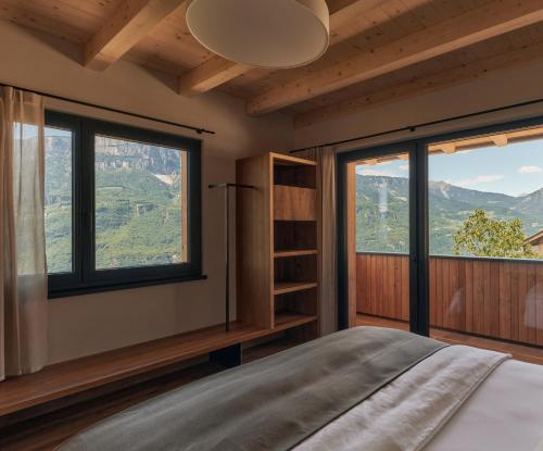 a bedroom with a bed and two large windows at Anima-Suites adults only in Terlano