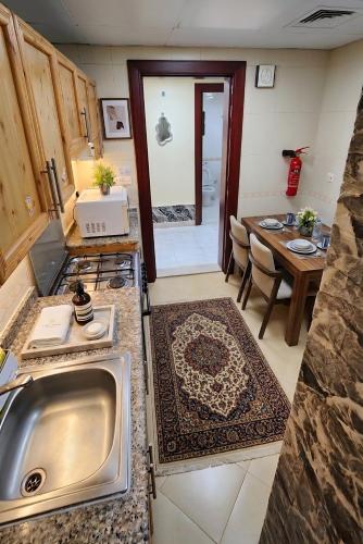 a kitchen with a sink and a table in a room at Fabulous Room in Muşaffaḩ