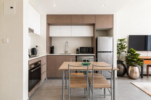 a kitchen with a table and chairs and a refrigerator at Sahab - Hermes Leather Home in Sharjah