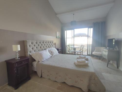 a bedroom with a bed and a dining room with a table at Le Charmant-Terrasse-Vue et accès Piscine -15 in Laredorte
