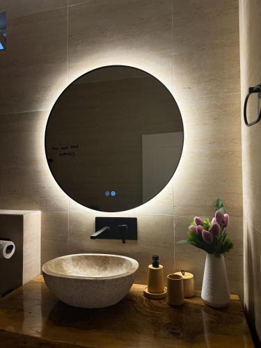 a bathroom with a sink and a mirror on the wall at Villa Ulu Piqeras in Piqeras