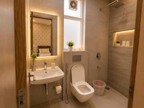 a bathroom with a sink and a toilet and a mirror at Hotel Akshay dream stay in Gurgaon