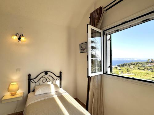 a bedroom with a bed and a large window at Villa Hera in Spartià