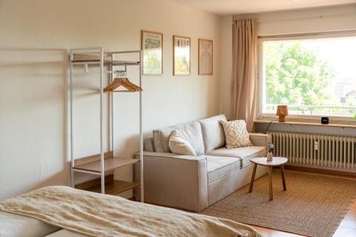 a bedroom with a couch and a bed and a window at Seeblick Apartment Meersburg in Meersburg