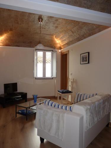 a living room with a couch and a table at Páteo dos Oliveira - Casa dos Serviçais in Évora