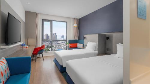 a hotel room with two beds and a window at Holiday Inn Express Kunming West by IHG in Kunming
