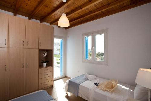 a bedroom with a bed and a large window at Sea Wind Villas and Suites in Tourlos