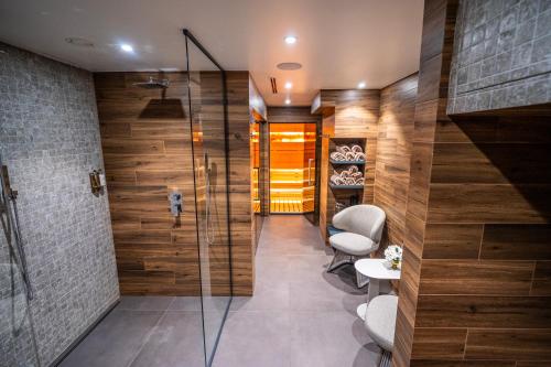 a bathroom with a walk in shower and a glass door at Хотел Дом на Алпиниста in Vratsa