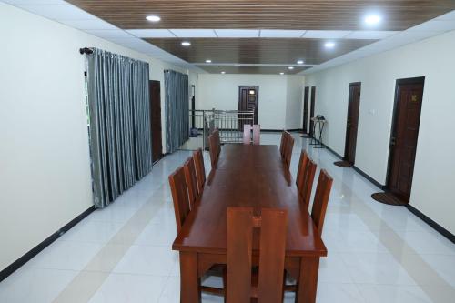 a long wooden table and chairs in a room at Oasis Guest House in Jaffna