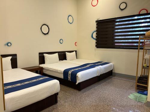 two beds in a room with clocks on the wall at Sun Moon Lake Jinlongshan BnB in Yuchi