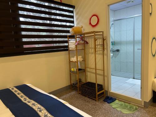 a bedroom with a shower and a teddy bear next to a bed at Sun Moon Lake Jinlongshan BnB in Yuchi