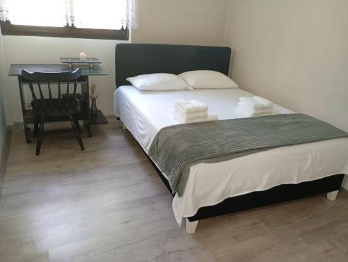 a bedroom with a bed with a chair and a desk at Gordana in Senjski Rudnik