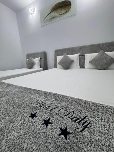 ein Schlafzimmer mit einem Bett und einer Bettdecke mit den Worten: in der Unterkunft Hotel Daly in Ploieşti