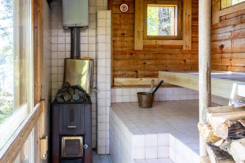 a kitchen with a stove in a cabin at Mökki Kalliola in Puumala
