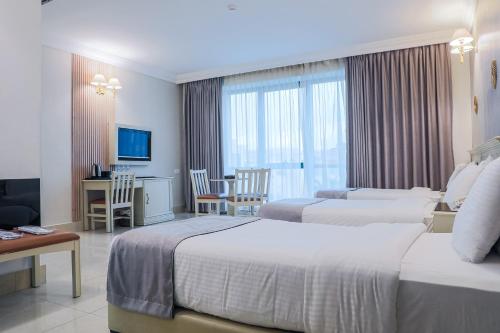 a hotel room with two beds and a television at Amman West Hotel , A Boutique Hotel in Amman