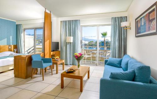 a living room with a blue couch and a bedroom at Blue Lagoon Resort in Lampi