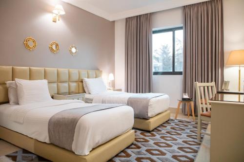 a hotel room with two beds and a window at Amman West Hotel , A Boutique Hotel in Amman