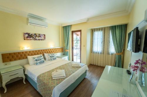 a hotel room with a large bed and a table at İlkiz Beach Hotel in Oludeniz