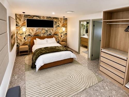 a bedroom with a large bed and a television at Peaceful tropical retreat with pool, mineral spa & Games room in Gold Coast
