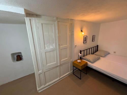 a small bedroom with a bed and a table at Bajatova Heritage House with Private Courtyard in Mostar