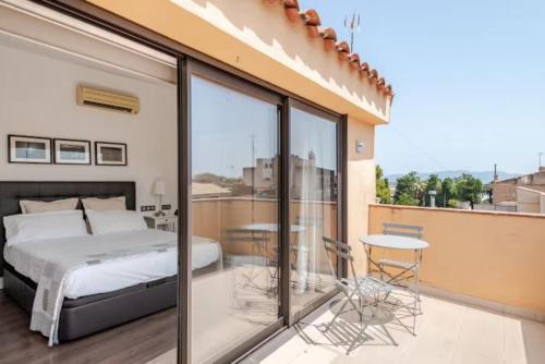a bedroom with a bed and a table on a balcony at Apartament La Placeta Figueres in Figueres