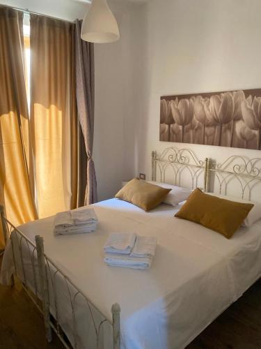 a bedroom with a white bed with towels on it at Il Campanile in Fondi