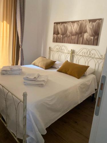a bedroom with a white bed with towels on it at Il Campanile in Fondi