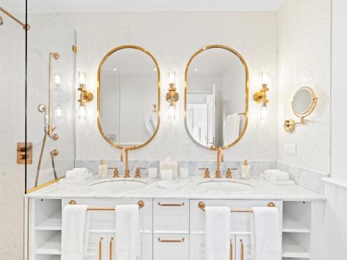 a bathroom with two sinks and two mirrors at La Sirène in Simpson Bay