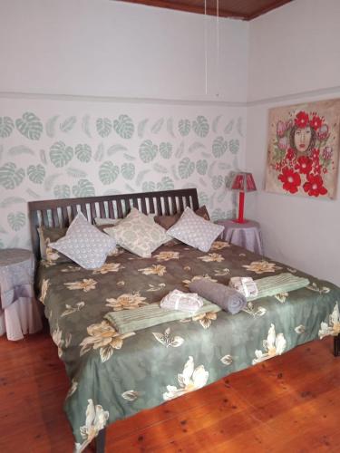 a bedroom with a bed with a flower patterned wall at Feather Foot Self catering Accommodation in Heidelberg