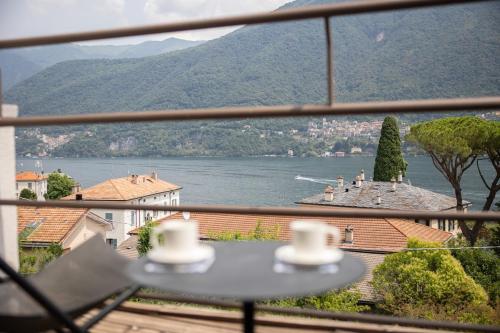 a view of a lake from a balcony with a table at The Como Pet Nest in Laglio