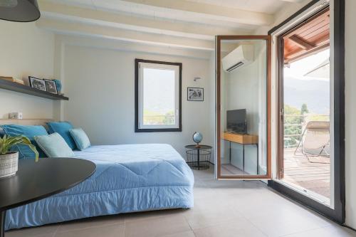 a bedroom with a bed and a table and a balcony at The Como Pet Nest in Laglio