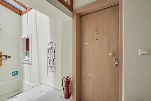 a wooden door in a hallway with a red fire hydrant at Kallichoron 3 fortezza Kavala in Kavála