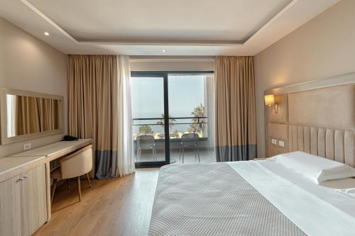 a hotel room with a bed and a desk and a window at Royal G Hotel & SPA 4 Star in Durrës