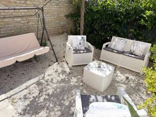 a group of chairs and tables in a yard at I Due Gelsi appartamento Green in Monte San Giusto