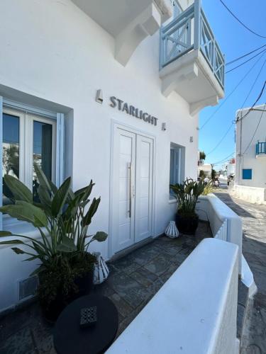 a white building with a door and a balcony at Starlight Luxury Studios in Mikonos
