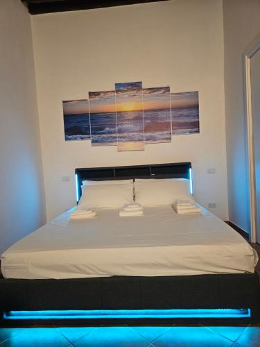 a bed in a bedroom with three paintings on the wall at Le Bonbon in Trevignano Romano