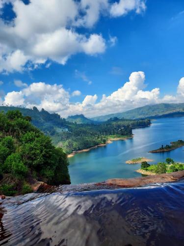 a view of a river with trees and mountains at Madhusha Rest in Maskeliya