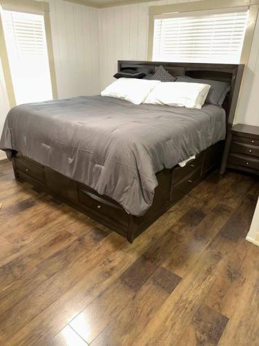 a large bed in a bedroom with a wooden floor at Hot Tub 5 beds in Moorhead