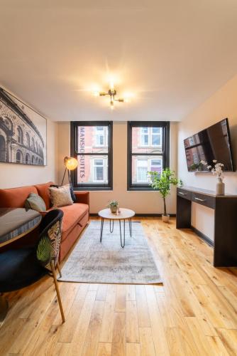 a living room with a couch and a table at LS1 - Luxury City Centre Apartments Leeds in Leeds