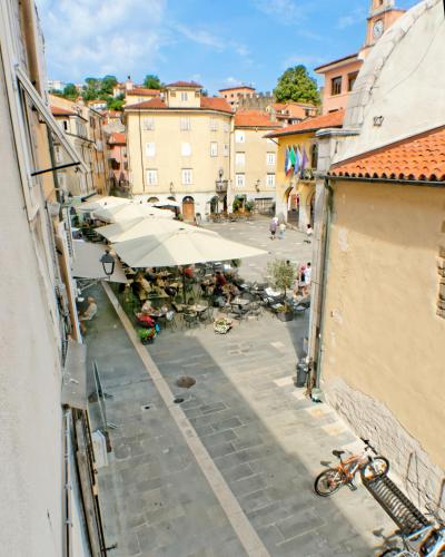 a view of a city street with tables and umbrellas at Casa Ada in Muggia