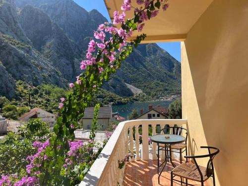 a balcony with pink flowers and a table and chairs at Apartman Vujović Orahovac in Trstenik