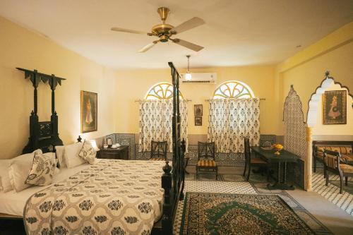 a bedroom with a bed and a ceiling fan at Hotel Bissau Palace in Jaipur